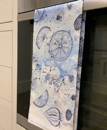A blue and white kitchen towel hanging on a wall.