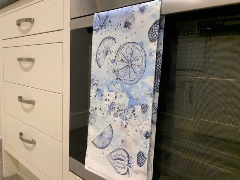 A blue and white kitchen towel hanging on a wall.