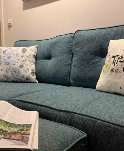 A blue couch with a magazine on it.