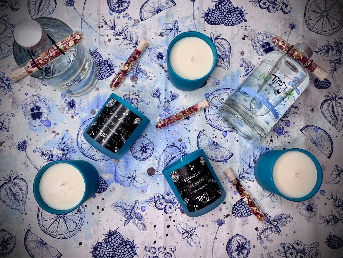 A set of candles and a bottle of water on a blue tablecloth.