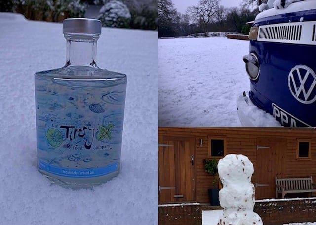 A snowman and a vw gin bottle in the snow.