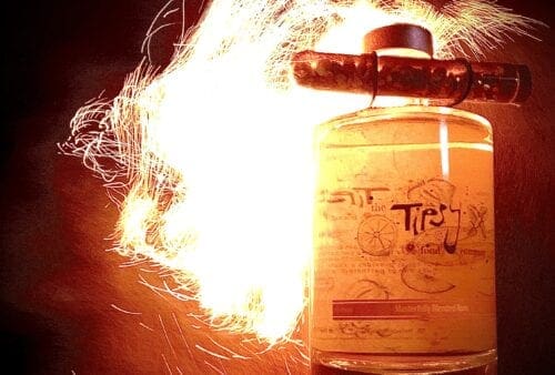 A bottle of liquor with fire coming out of it.