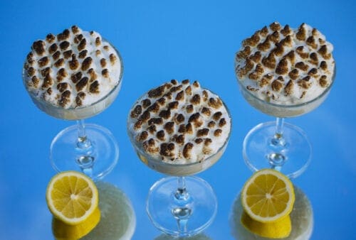 Three glasses of ice cream with marshmallows and lemon slices.