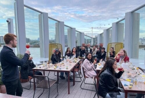 A group of people sitting at tables on a rooftop.