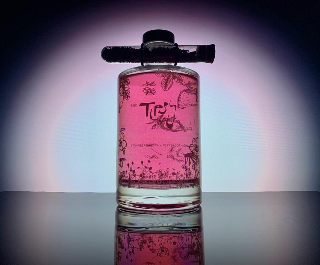 A bottle of pink gin sitting on a table.