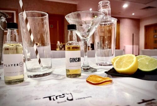 A table with a bottle of gin and a slice of lemon.