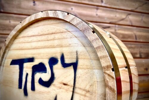 A wooden barrel with the word tryy painted on it.