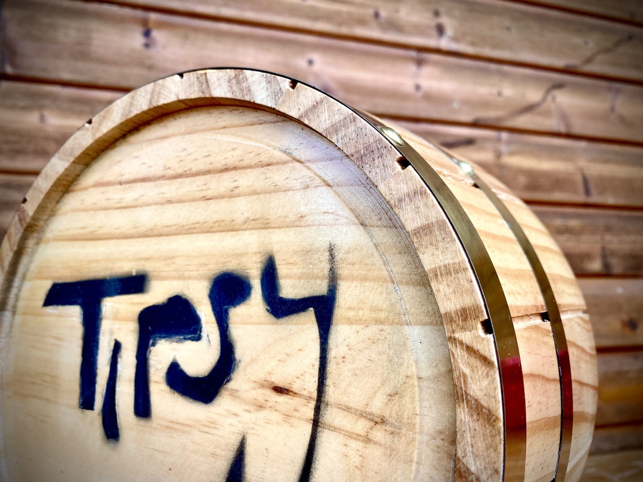 A wooden barrel with the word tryy painted on it.