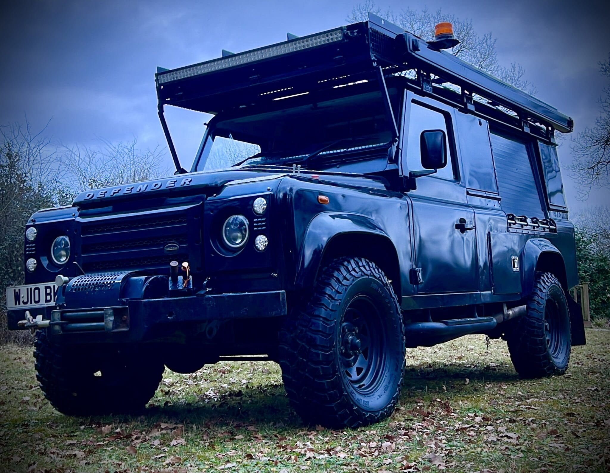 A black land rover parked in a field.