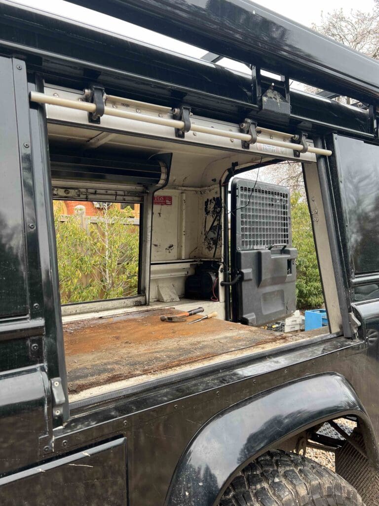 A black land rover with the door open.