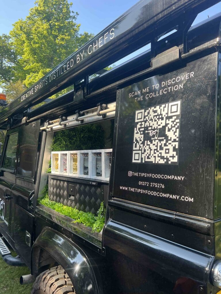 A black land rover with a qr code on the back.